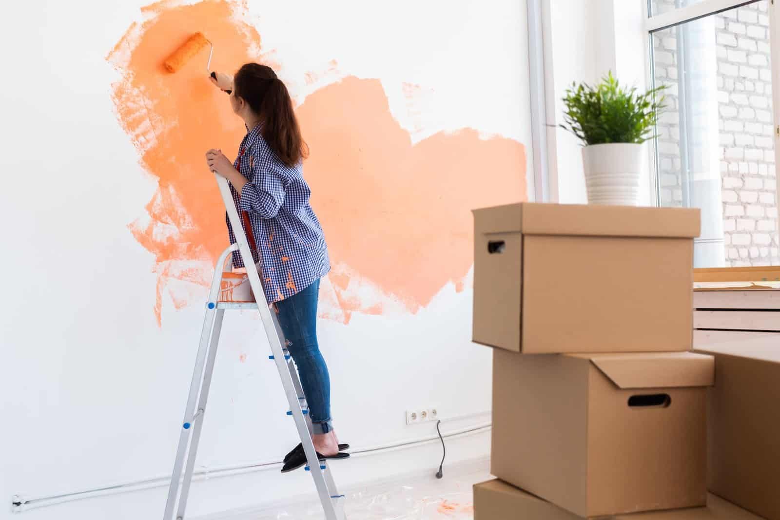 Brightening a wall with peach-colored paint in a home renovation project.